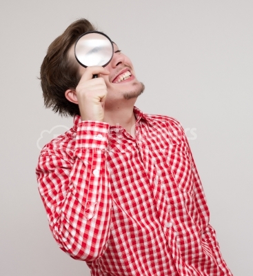 Businessman looking through magnifying glass.