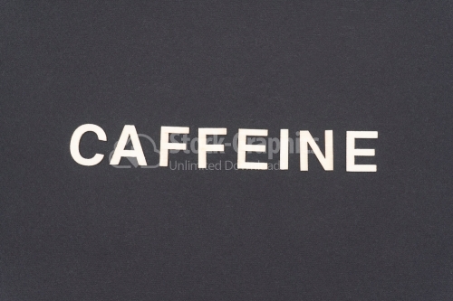 CAFFEINE word written on dark paper background. CAFFEINE text for your concepts