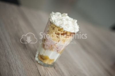 Dessert with cream and fruit yoghurt on a wooden background
