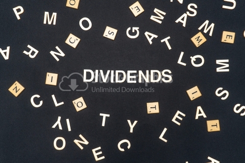 DIVIDENDS word written on dark paper background. DIVIDENDS text for your concepts