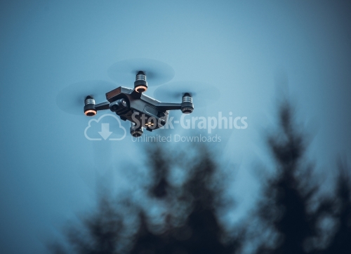 Drone with digital camera, hovering in blue sky