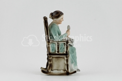 Grandmother reading with lupe porcelain statuette