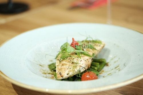 Grilled chicken breast, asparagus, tomatoes and dill on white plate.