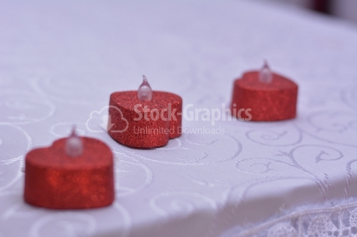 Heart-shaped candles on a white table