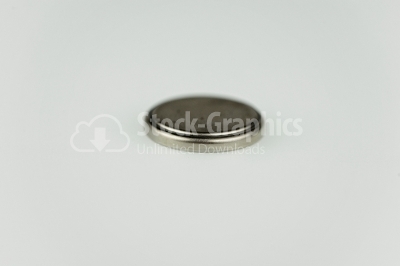Lithium button cell on white - Stock Image