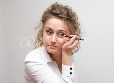 Makeup woman. Cute cosmetics woman having fun with make-up produ