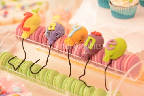 Pink and green macarons and colorful marzipan balloons