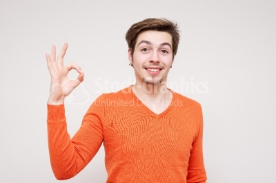 Portrait of a young man showing ok sign with a large smile on hi
