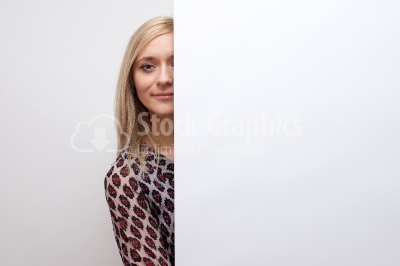 Pretty female student posing behind a white panel isolated on wh