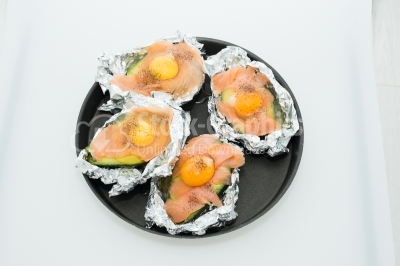 Raw eggs on pieces of salmon and avocada, put in the tray