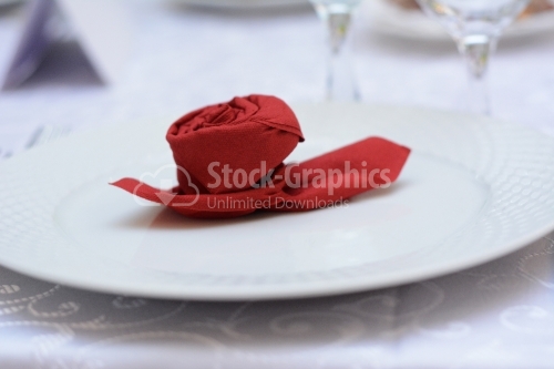 Red rose made of paper on a white plate