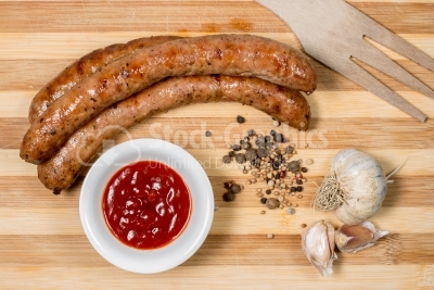 Sausages and ketchup on the wooden table