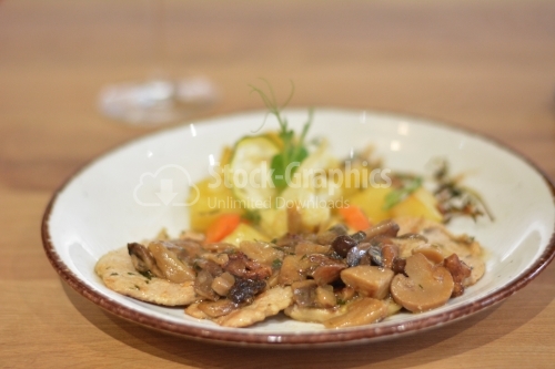 Sauteed mushrooms with a garnish of potatoes and peppers.