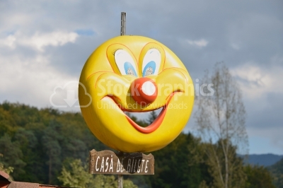 Smiling yellow balloon on blue sky background