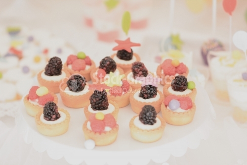 Vanilla cream mini tarts decorated with raspberries and blackberries