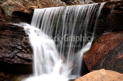 Waterfall on river in red mountains