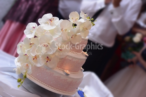 White wedding cake decorated with pink lace and white orchid