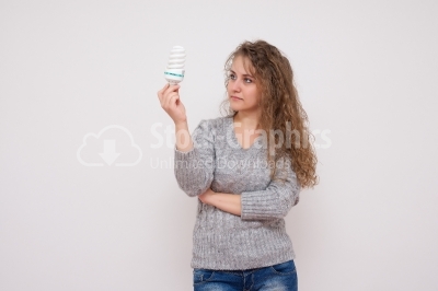 Woman holding an energy saving lightbulb - isolated over white
