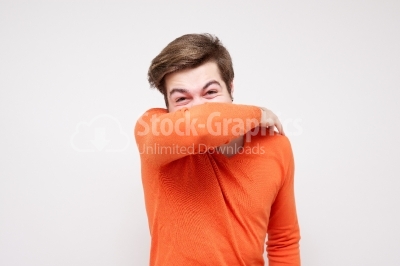Young man coughs and holds the arm in front of the mouth