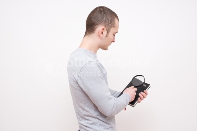 Young man look through magnifying glass 