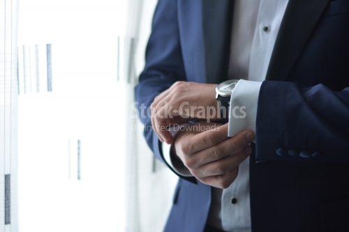 Young man puts his watch on his hand. Groom. Businessman.
