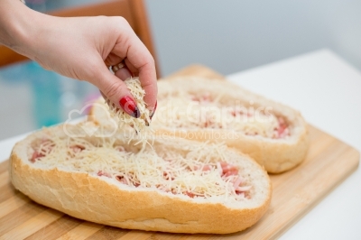 A different pizza with a hand that sprinkle parmesan