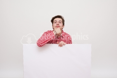 A smiling handsome male posing behind a white panel isolated 