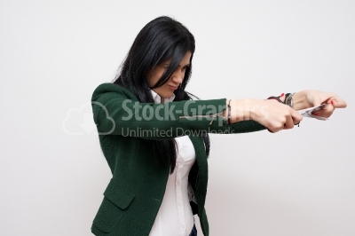 A young woman is cutting through her credit card with scissors. 