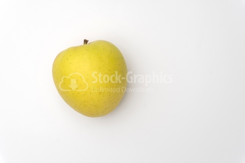 An isolated golden delicious apple with water beads on white bac