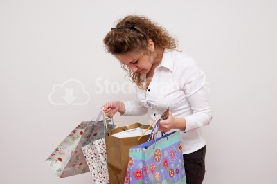 Beautiful girl looking into colorful shopping bags 