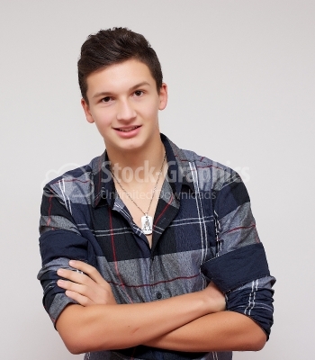 Casual young man looking at camera with arms crossed and 