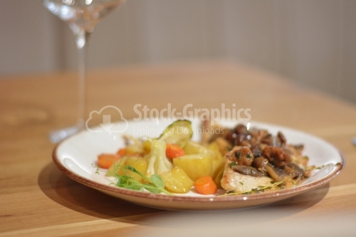 Chicken breast with sauteed mushrooms and vegetable garnish.