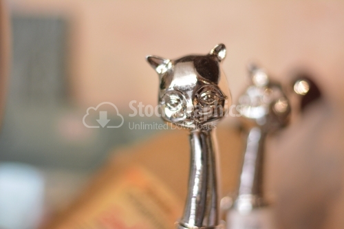 Close view of a silver cat head decorative object.