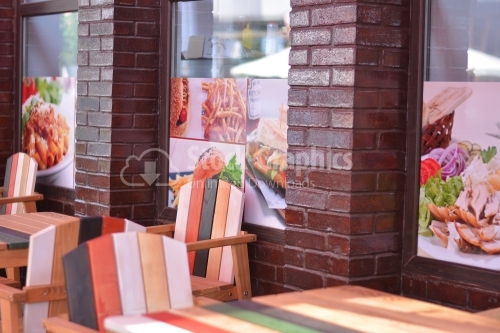 Colored wooden chairs and tables. Terrace of a fast food restaurant.