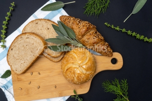 Composition with bread on cutting board, top view