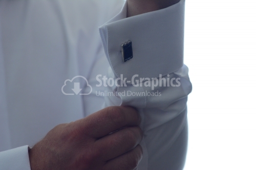 Concept successful businessman. The groom fasten cufflinks on the cuffs of the shirt. The businessman fasten cufflinks on the cuffs of the shirt.