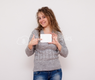 Curly haired woman with white placard and smiling