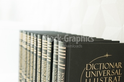 Dark books with hard covers on a white shelf perspective view.