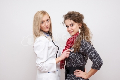 Doctor examining a female patient with stethoscope