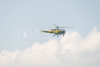 Flying helicopter on the cloudy sky