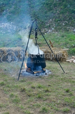 Food in a cauldron on a fire. Cooking outdoors in cast-iron caul