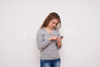 Girl sending a text message on her smartphone isolated 