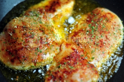Golden crisp chicken thighs with herbs and spices - Stock Image