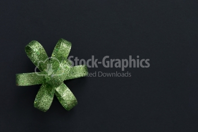 Green gift bow on dark background