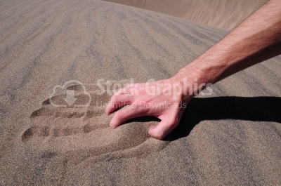 Hand of a man in the sand