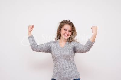 Happy beautiful woman with arms raised in success - Stock Image