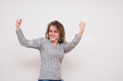 Happy beautiful woman with arms raised in success - Stock Image