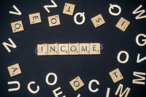 INCOME word written on dark paper background. INCOME text on dark for your designs, concept.