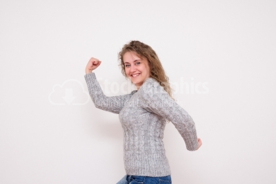 Laughing Young Woman Shows Arm Muscle - Stock Image