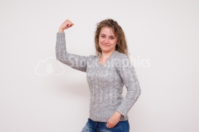 Laughing Young Woman Shows Arm Muscle - Stock Image